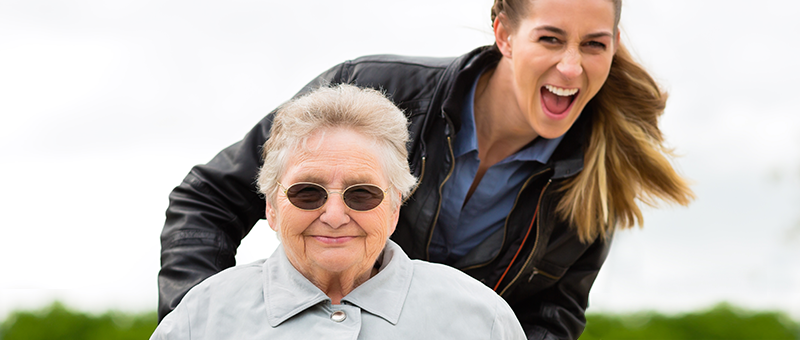 Woman and older lady having fun playing mobile app game