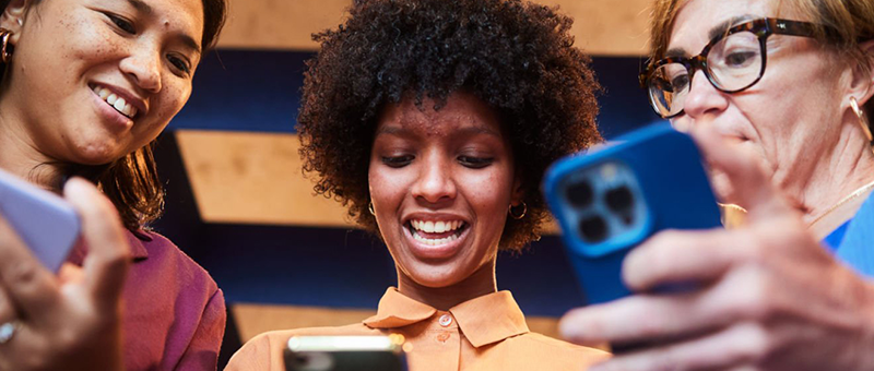 Three colleagues playing a mobile game together