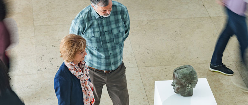 Visitors examining an art object