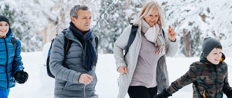 Family walking in snow playing mobile game