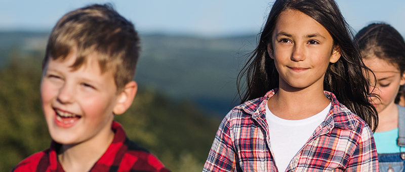 Three kids walking in the mountains