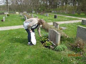 2015 04 30. Min far Eriks grav. Maria kollar blommorna, och gravstenen som behöver tvättas. Fotonr: IMG_1589